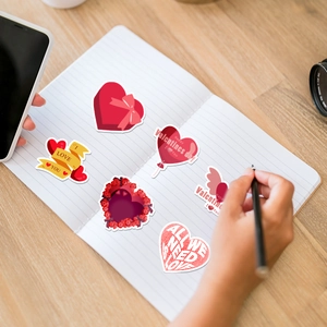 Detail of red Valentine heart stickers with I LOVE YOU text on a wooden desk