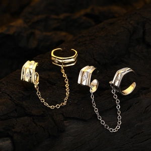 Elegant gold and silver star ear cuffs with tassels and rhinestones on dark wood background
