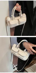 Detail of cream saddle bag with front pockets shown on black coat and handheld styling