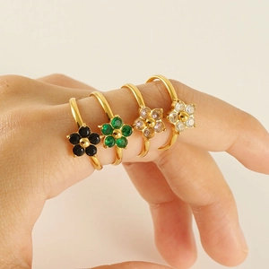 Macro shot of gold flower rings set with colorful zircons worn on fingers for detail