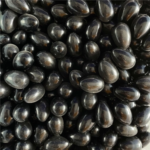 Close-up of polished black agate egg-shaped gemstones with glossy smooth surface finish