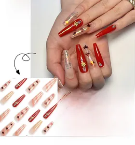Detailed view of red and gold ballerina nails with maple leaf art and sparkling rhinestones