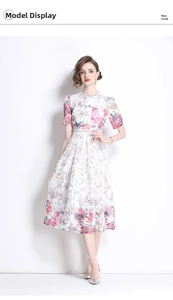 Details von weißem Kleid aus Hohlspitze mit elegantem Blumen- und Schmetterlingsdruck