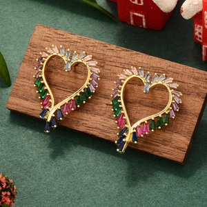 Close-up of golden heart earrings with colorful zircon stones on a wooden stand