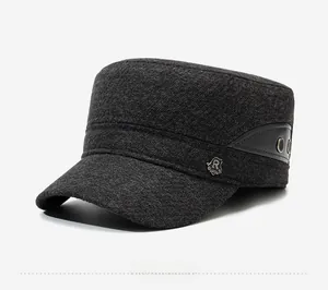 Detail of wool flat top cap for men featuring metal logo and side leather trim