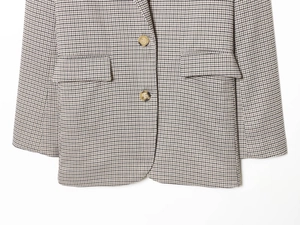 Nahaufnahme eines Blazers mit Hahnentrittmuster, Strukturstoff und Schildpattknöpfen