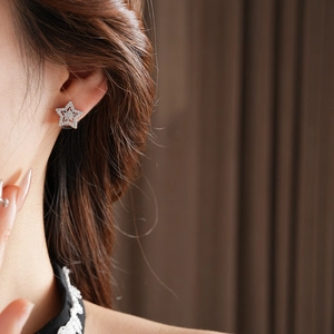 Close-up of silver star earrings with micro-set zircon on model for a refined look