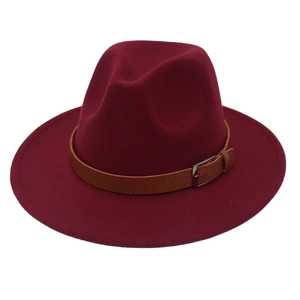Close-up of burgundy fedora hat with brown leather belt buckle and wool felt texture