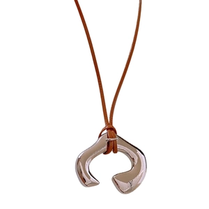 Irregular silver U-shaped metal pendant necklace with brown leather cord on white background