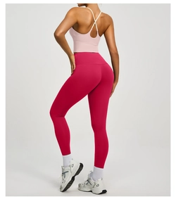 Rückansicht des rosa Sport-BHs mit Kreuzgurten und magentafarbenen Yoga-Leggings