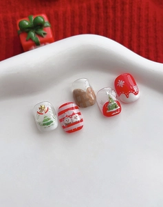 Macro shot of 5 Christmas nail art pieces with snowman and gingerbread man designs