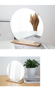 Minimalist round acrylic mirror detail with rectangular wooden base in a Nordic room