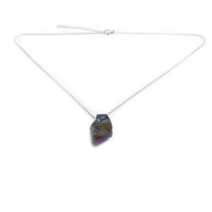 Detailed shot of an irregular natural iridescent stone pendant with a silver metal chain