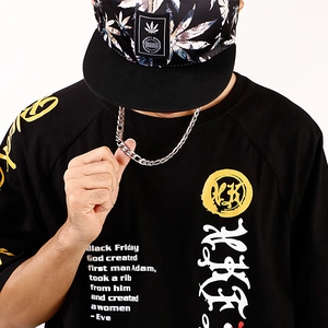 Détail du collier minimaliste en acier inoxydable porté avec t-shirt noir et casquette