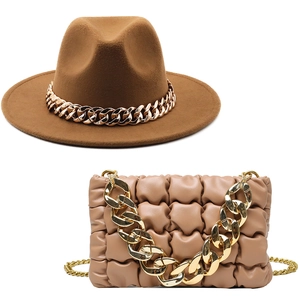 Close-up of brown wool fedora and beige pleated handbag set with chunky gold chains