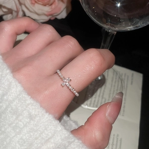 French style pearl ring with a zircon cross pendant worn on a finger in an elegant setting