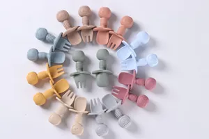 Detailed close-up of colorful baby silicone spoons and forks with anti-choke round guards