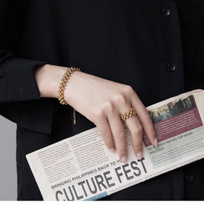 Detailed shot of gold-plated multi-layer beaded bracelet and ring with lifestyle backdrop