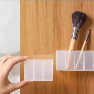 Wall-mounted transparent storage box for makeup brushes with adhesive backing