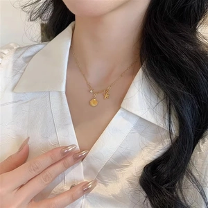 Élégant collier doré avec pendentif étoile de mer et coquillage sur le cou d'un modèle