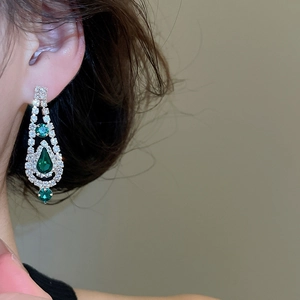 Macro shot of silver earrings with emerald-cut crystals and sparkling rhinestones