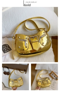 Detail view of gold metallic biker bag featuring silver rivets and wide adjustable strap