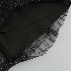 Detail of black mesh dress showing shimmering silver sequins and silky inner lining