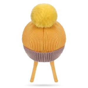 Bright yellow winter knit baby hat with pink trim and a fluffy pom pom