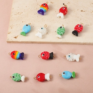 Detail view of colorful handmade glass clownfish charms with metal loops for DIY jewelry