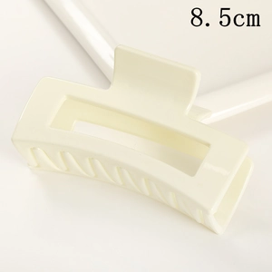 Close-up of 8.5cm beige rectangular matte hair claw clip with cutout design on white background
