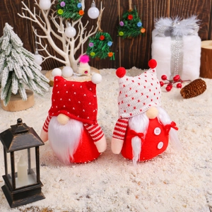 Pair of festive Christmas gnomes with knitted hats and white beards on snow background
