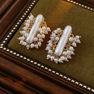 Vue détaillée de boucles d'oreilles vintage avec perle centrale et contour de perles