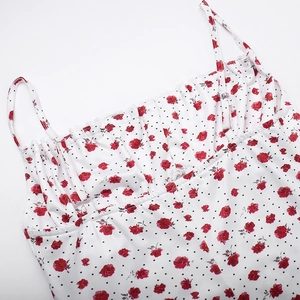 Detalle de vestido blanco con flores, rosas rojas, bordes de encaje y tirantes finos