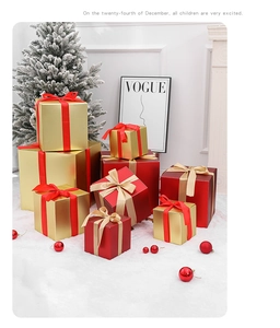 Detail of red and gold Christmas gift boxes with satin bows on a faux fur snow setting