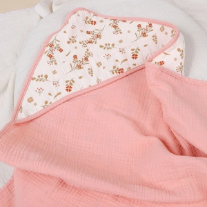 Detail showing soft pink four-layer muslin cotton baby blanket with floral pattern