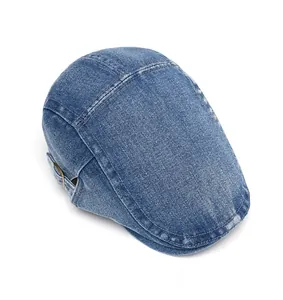 Detail of blue denim flat cap showing washed texture and side metal buckle adjustment