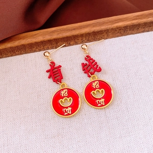 Macro view of Chinese New Year drop earrings with red enamel lucky characters and gold finish