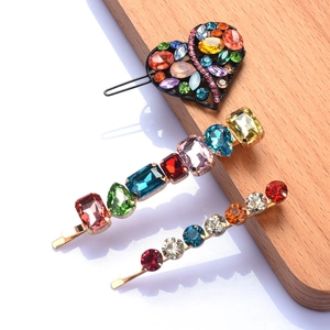 Detail of three-piece hair clip set with colorful rhinestones and heart-shaped gemstone
