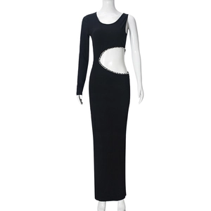 Détail d'une robe noire asymétrique montrant des strass le long de la découpe taille