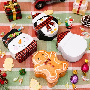 Close-up of four festive Christmas tin boxes featuring penguin, snowman and gingerbread man