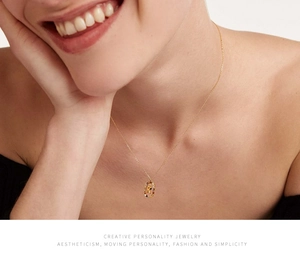 Close-up of gold letter P necklace with colorful crystals on model neck