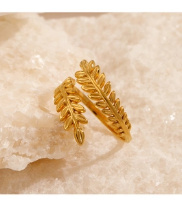 Vue macro d'une bague feuille dorée ajustable posée sur une pierre de cristal