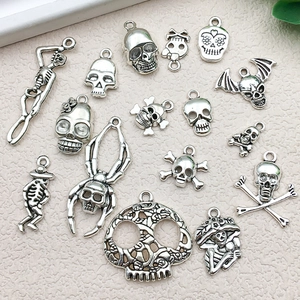 Detailed macro shot of vintage silver skull and skeleton alloy charms for DIY jewelry