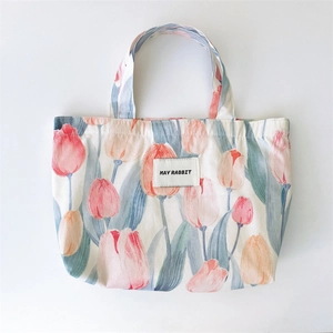 Detailed top view of tulip floral canvas tote bag featuring MAY RABBIT woven label