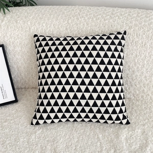 Detail of a modern black and white geometric triangle pillow case on a white sofa