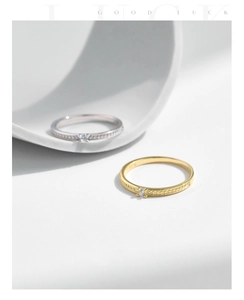 Detail of minimalist gold and silver rings with single zircon and beaded texture