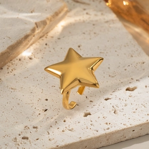 Minimalistischer verstellbarer Goldstern-Ring auf einer hochwertigen beige Travertinfläche