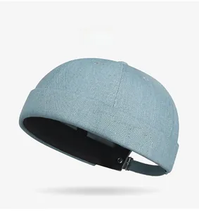 Detail of light blue denim skull cap with pink Music Club embroidery and metal buckle