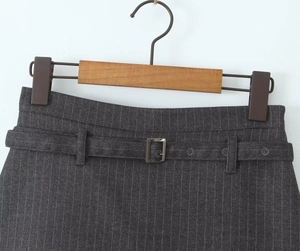 Detail of dark grey striped skort featuring a matching belt with a square metal buckle