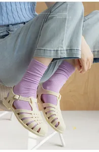Detail view of purple ribbed knit cotton socks paired with vintage cutout sandals